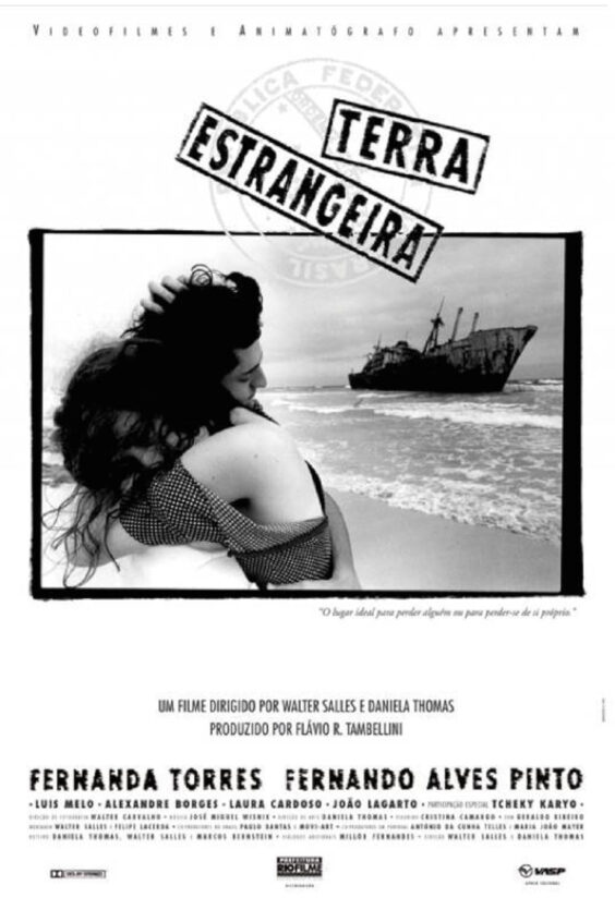Fremmed land. Plakat for filmen "Terra Estrangeira" regissert av Walter Salles og Daniela Thomas. Hovedroller: Fernanda Torres, Fernando Alves Pinto. To personer omfavner hverandre på en strand med skipsvrak i bakgrunnen.