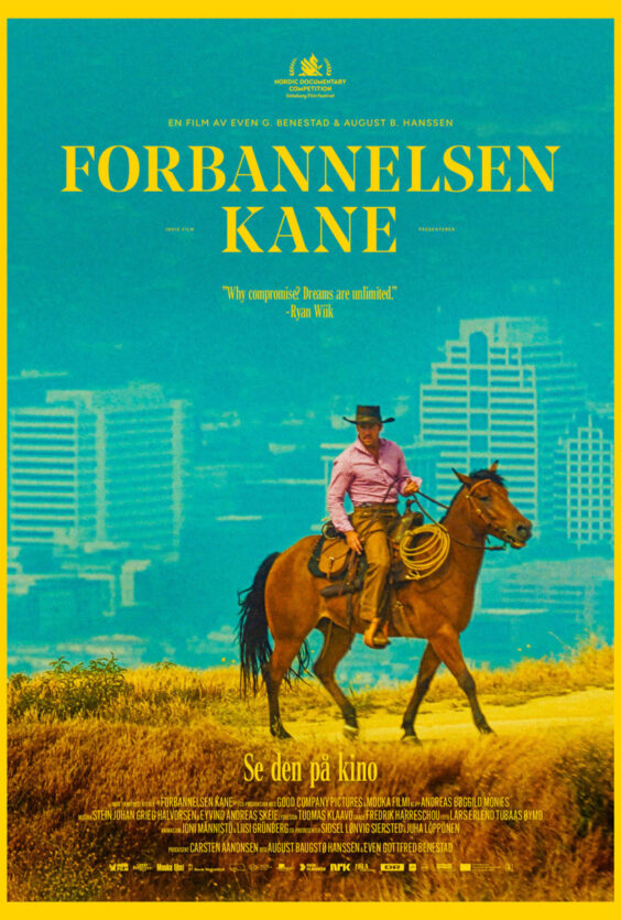 Forbannelsen Kane En mann med hatt og rutete skjorte rir på en brun hest Tørt landskap Høye bygninger i bakgrunnen