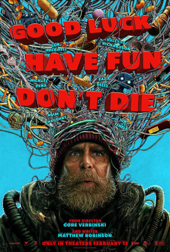 Good Luck Have Fun Dont Die En mann med skjegg og lue har mange ledninger koblet til hodet Store røde bokstaver og små gjenstander er synlige rundt ham på blå bakgrunn