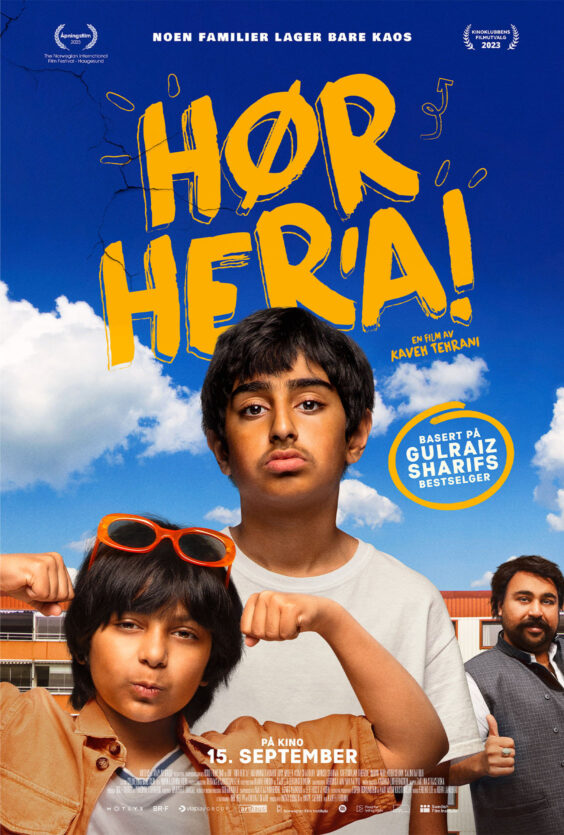 Hør Hera To barn står foran en skolebygning med blå himmel og skyer bak Den ene har oransje solbriller Begge viser muskler med armene En mann står til høyre i bakgrunnen