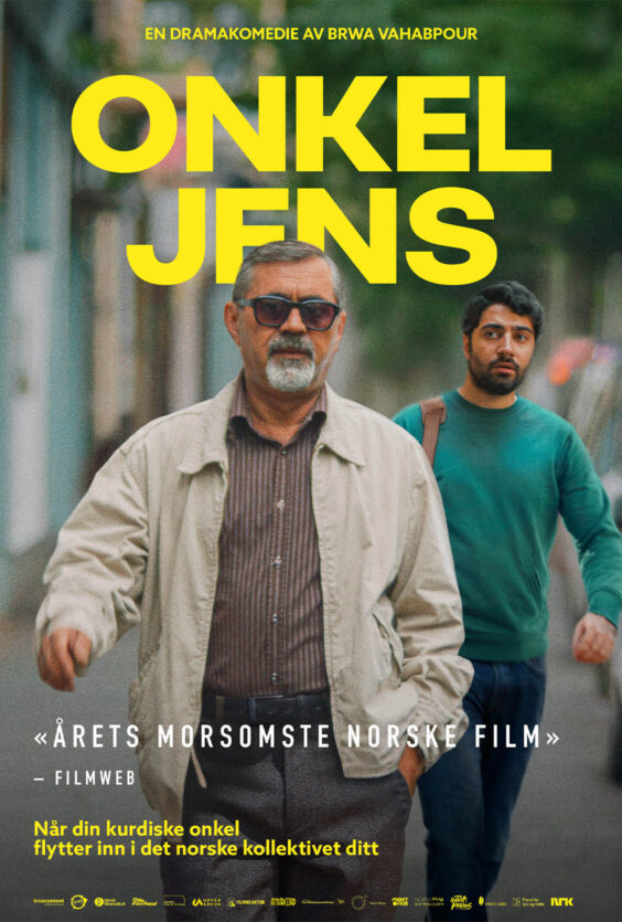 Onkel Jens Mann med solbriller og lys jakke går langs en gate med parkerte biler og bygninger i bakgrunnen